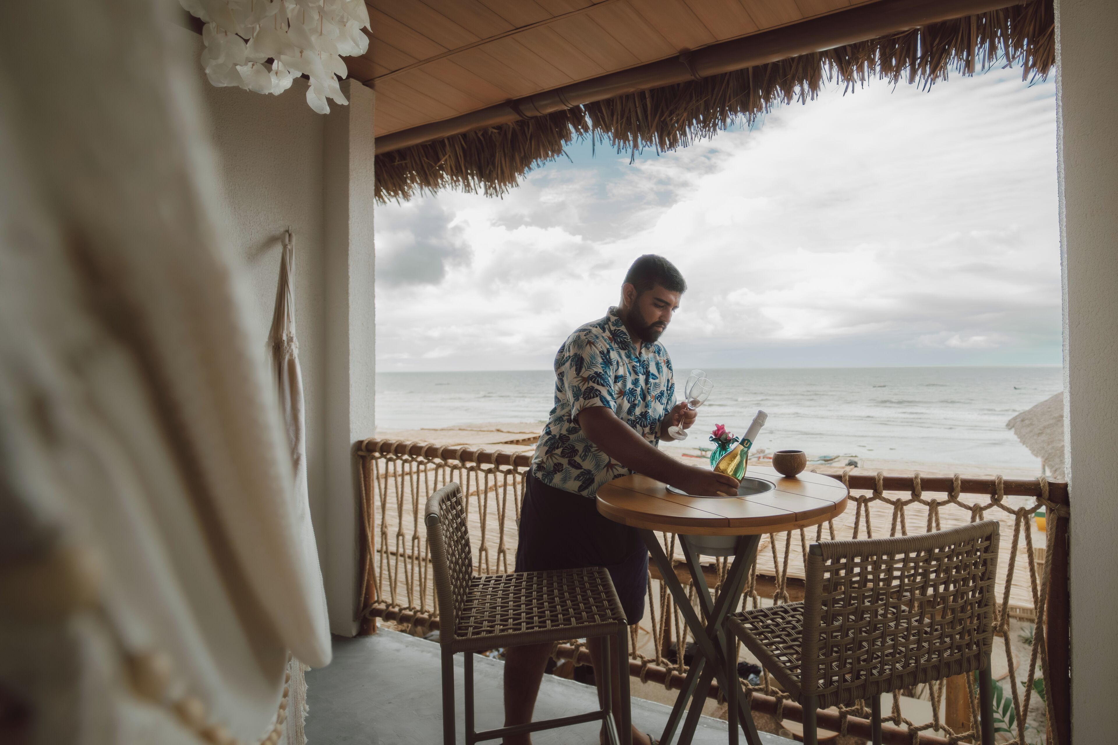 A man sitting at a table with a view of the ocean.