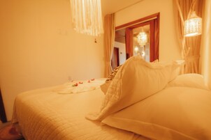 Una habitación de hotel con una cama, un espejo y una araña.