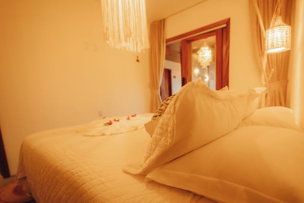 Una habitación de hotel con una cama, un espejo y una araña.