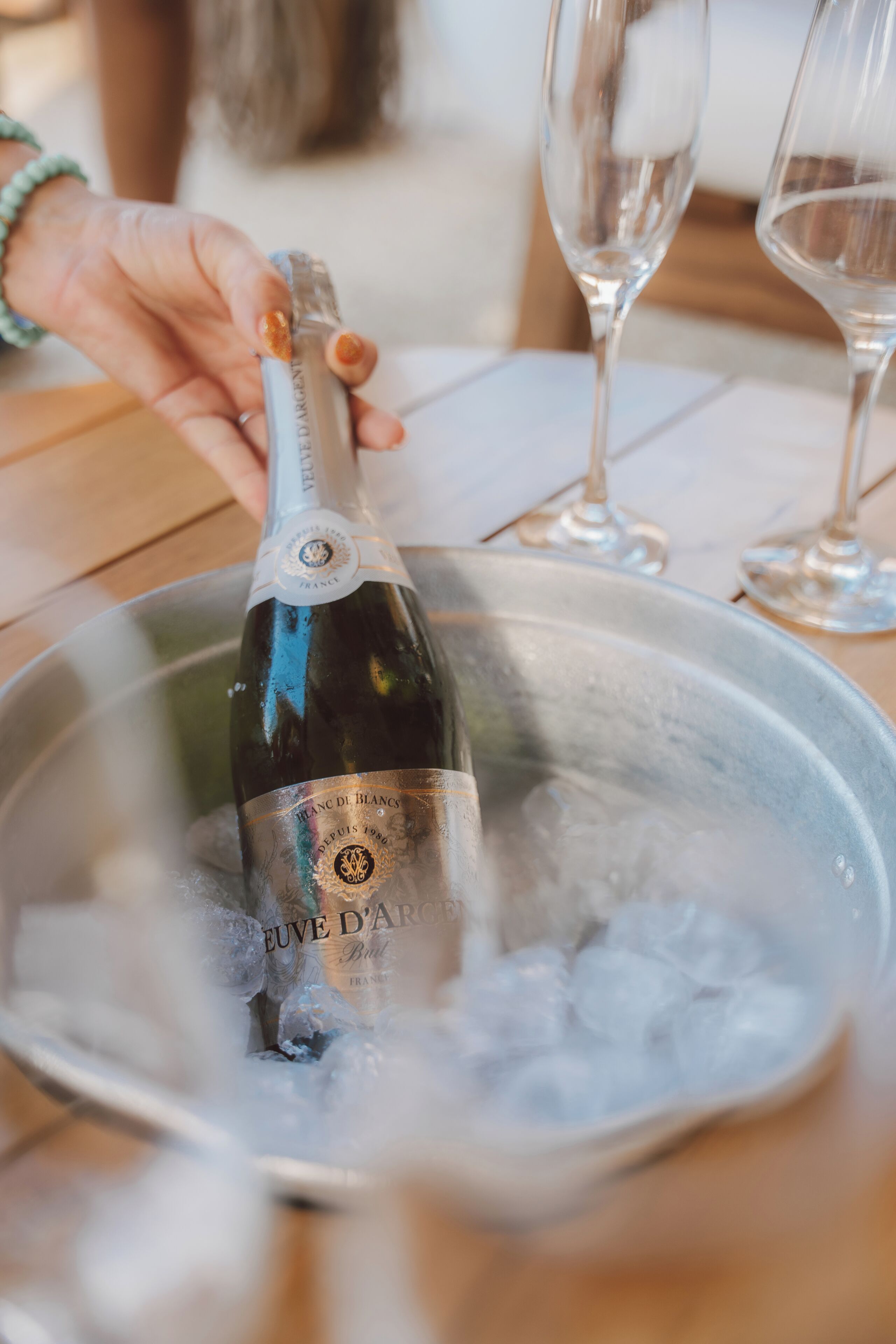 Una botella de champán en un balde metálico lleno de hielo.