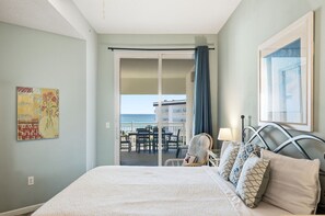A hotel room with a bed, a chair, a table, and a view of the sea. - Magical 3rd-floor condo with pools, telescope for stargazing & pickleball (Santa Rosa Beach)