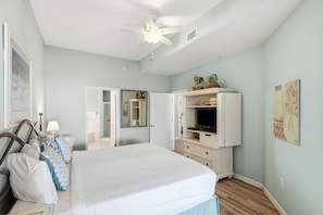 A bedroom with a bed, a wardrobe, a ceiling fan, and a bathroom door. - Magical 3rd-floor condo with pools, telescope for stargazing & pickleball (Santa Rosa Beach)
