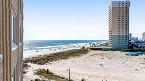 A beachfront hotel with a view of the ocean and beach.