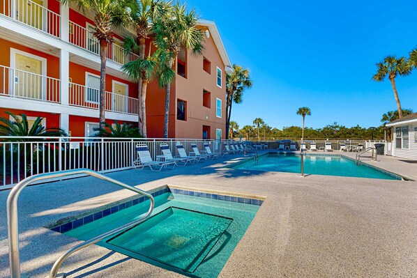 Un área de piscina de hotel con múltiples sillas de descanso y una piscina azul cristalina.