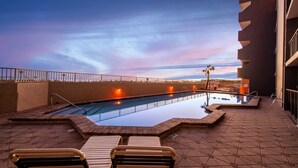 Et tag med swimmingpool, klare vanger og liggestole.