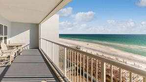 Ein Balkon mit Blick auf Strand und Meer.
