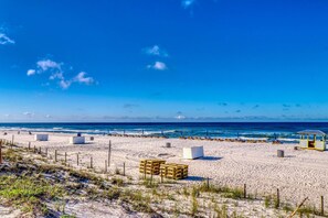 A beach with sand, ocean, and a lifeguard tower.