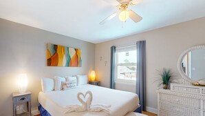 Une chambre à coucher bien rangée, avec un lit, une lampe de chevet et un élément décoratif mural.