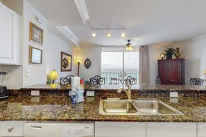 Eine Küche mit Granit-Arbeitsplatten, einer Edelstahl-Spüle und einem Whirlpool Geschirrspüler.