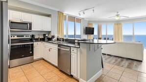 Una cocina moderna con gabinetes blancos, electrodomésticos de acero inoxidable y una isla grande.