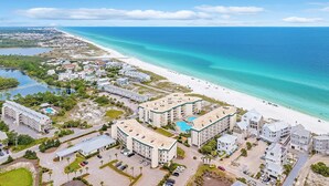 Ein Hotel an der Küste mit mehreren Gebäuden, einem Strand und freiem Blick auf den Ozean.