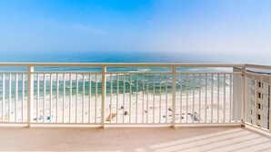 A balcony with a view of a beach and ocean. - 13th-floor condo with amazing views, pools, gym & beach access (Perdido Key)
