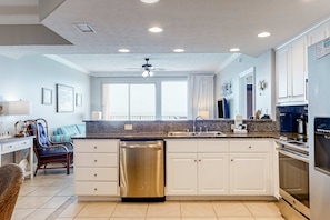 A modern kitchen with white cabinets, a stainless steel dishwasher, and a granite countertop. - Beachside condo with a pool, hot tub, washer/dryer, beach access - snowbirds OK (Panama City Beach)
