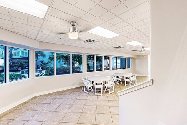 A spacious room with large windows, a tiled floor, and ceiling fans. - 2nd-floor, oceanfront condo with Gulf view, W&D, heated pool, & large balcony (Fort Walton Beach)
