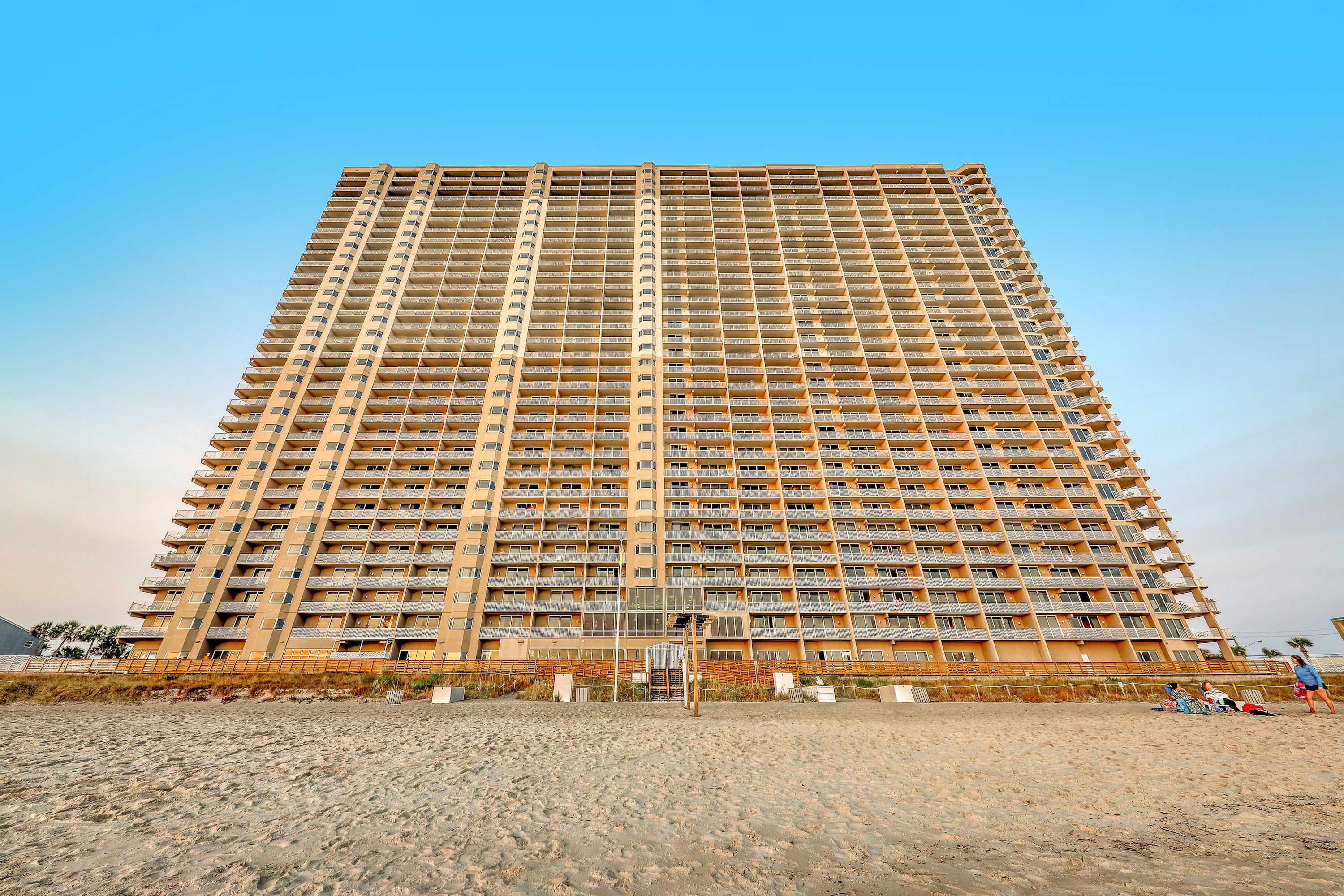 A tall, multi-story hotel with a uniform facade and balconies.
