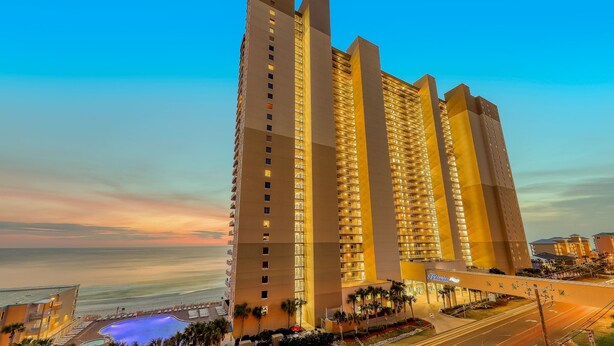 A high-rise hotel with multiple floors, a swimming pool, and a view of the ocean. - Exclusive Gulf-front condo | panoramic views | Pools & Hot tub (Panama City Beach)