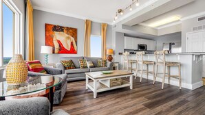 Een moderne woonkamer met een bank, salontafel en een schilderij aan de muur.