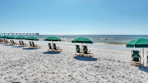 A beach with rows of green umbrellas and beach chairs. - Ground-Floor Condo At Waterscape 490 Feet Of Private Beach (Fort Walton Beach)