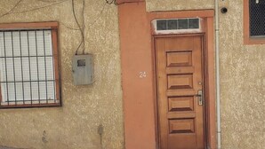 A building with a brown door marked with the number 24, a window with metal bars, and a utility box on the wall. - Whole house: apartment - Béjaïa, Algeria (Béjaïa)