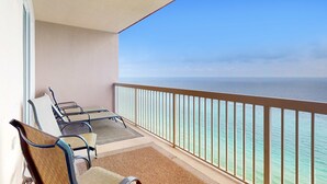 Varanda com vista para o oceano, uma mesa com cadeiras e um corrimão.