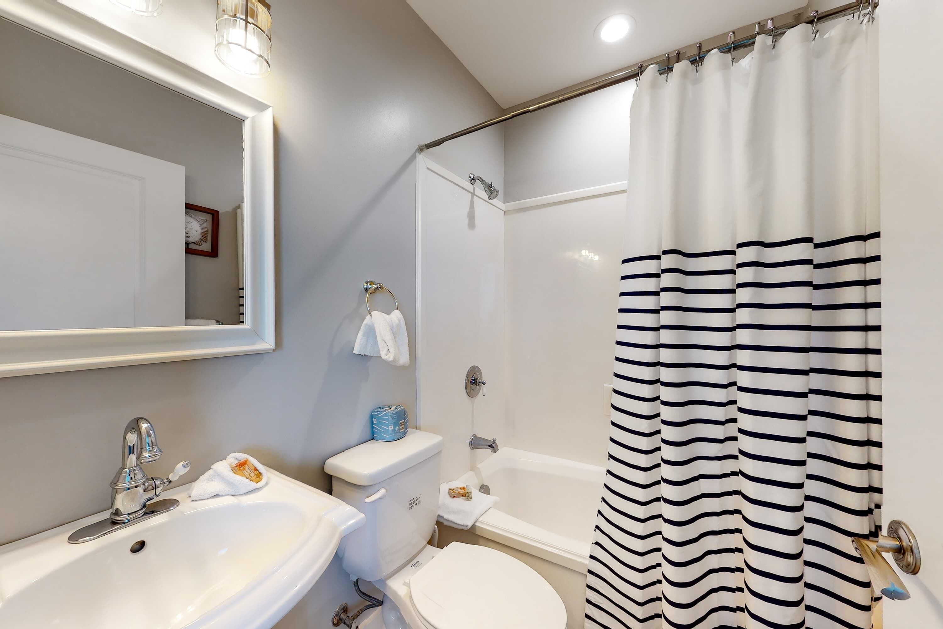 A bathroom with a white sink, toilet, and bathtub.