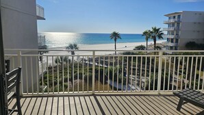 Un balcone con vista sulla spiaggia e palme.