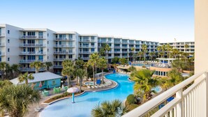 Un hotel con varios balcones, piscina y palmeras.