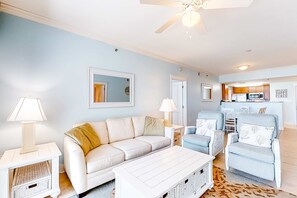 A living room with a sofa, armchairs, a coffee table, and a dining area with a kitchen in the background. - 3rd Floor Beachy Condo At Waterscape 490 Feet Of Private Beach (Fort Walton Beach)