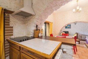 Eine Küche mit einer großen Kochinsel, Holzschränken und einer Steinwand.