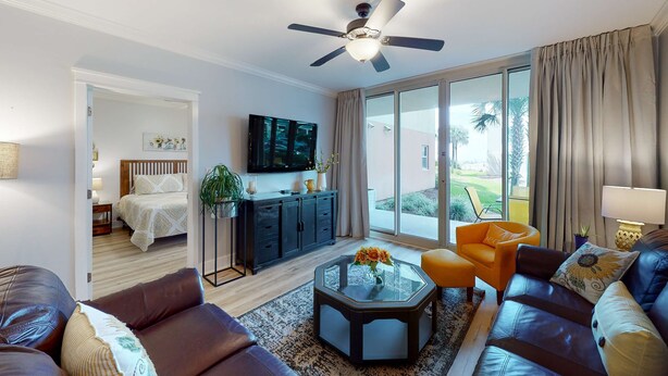 A modern living room with a sofa, armchair, coffee table, and a TV. - Handicap accessible ground-floor condo on Okaloosa Island Waterfall, Lazy River (Fort Walton Beach)