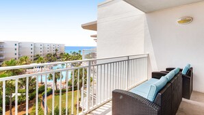 A balcony with wicker furniture, a pool view, and a white railing. - 6th Floor Cozy, 'At Home' Condo At Waterscape Steps To Beach Lazy River (Fort Walton Beach)