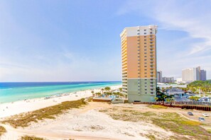 A tall hotel with a beach view, located near a sandy beach and the ocean. - Beachfront Condo with Access to Pool, Gym, & Game Room - Snowbirds Welcome (Panama City Beach)