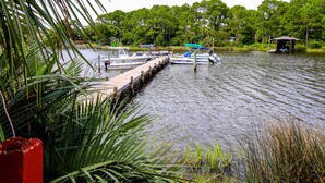 A dock with boats and a small pavilion by the water. - Cozy condo in paradise with pool, sauna & private dock - snowbird-friendly (Panama City Beach)