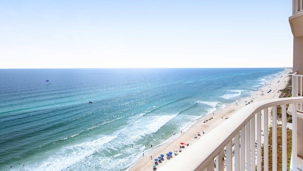 A beachfront hotel with a balcony overlooking the ocean, beach umbrellas, and a clear view of the sea. - 16th-floor waterfront condo with fast WiFi, Gulf view, pools, hot tubs, & gym (Panama City Beach)