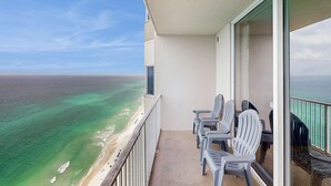 Ein Balkon mit Blick auf den Ozean, ausgestattet mit einer Sitzecke mit Stühlen und einem Tisch.