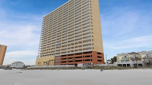 Ett högt hotell med flera våningar och en enhetlig exteriör, beläget nära en strand.