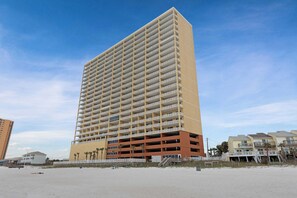 A tall, multi-story hotel with a uniform exterior, located near a beach. - Beachfront penthouse with 2 free beach chairs, WiFi, amazing views, pool & hot tub (Panama City Beach)