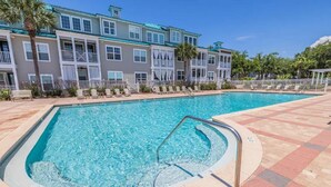 A swimming pool with a 3 ft depth marker, surrounded by a tiled deck and a building with balconies. - Blue Mountain Beach – charming 2nd floor condo with pool view (Santa Rosa Beach)