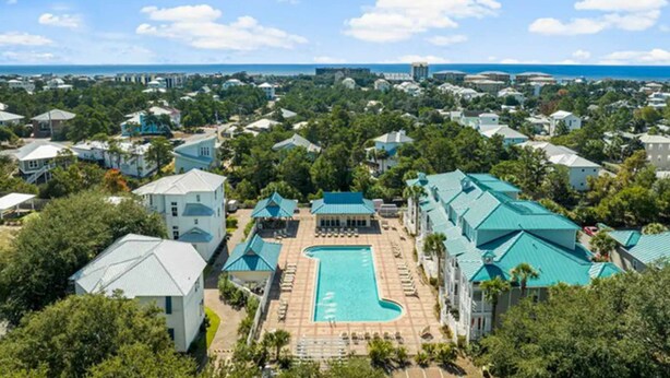 A resort with a central pool, multiple buildings, and a view of the ocean. - Blue Mountain Beach – charming 2nd floor condo with pool view (Santa Rosa Beach)