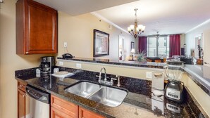 A kitchen with granite countertops, stainless steel sinks, a coffee maker, and a blender. - Inviting, Spacious Condo On Okaloosa Island Playground, 2 Hot Tubs (Fort Walton Beach)