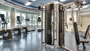 A gym with cardio machines, weight training equipment, and a mirrored wall. - Inviting, Spacious Condo On Okaloosa Island Playground, 2 Hot Tubs (Fort Walton Beach)