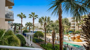 Un resort con zona de piscina, palmeras y vistas de los edificios circundantes.