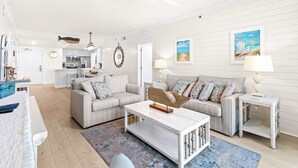 Ein großzügiges Wohnzimmer mit einer Couch, einem Couchtisch und einem Essbereich mit Stühlen und einem Tisch.