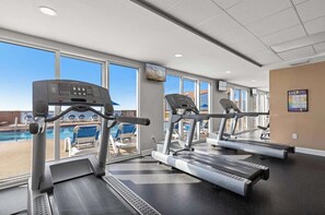 A gym with treadmills and a pool view. - Gulf-front condo with high-speed WiFi, pools, hot tubs & beach access (Panama City Beach)
