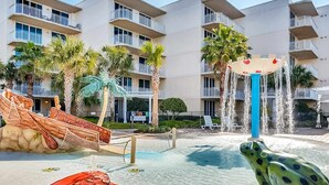 A pool area with a water slide, a frog statue, and a castle-shaped water fountain. - 3rd Floor Spacious Condo At Waterscape Children's Playground, 2 Hot Tubs (Fort Walton Beach)