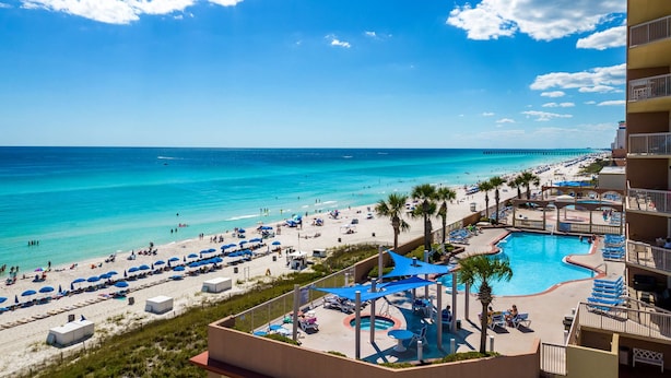 Een resort met zwembad, strand en uitzicht op de oceaan.