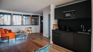 A modern kitchen with dark cabinetry and a built-in microwave. - LES 12 DE LARROS (Gujan-Mestras)
