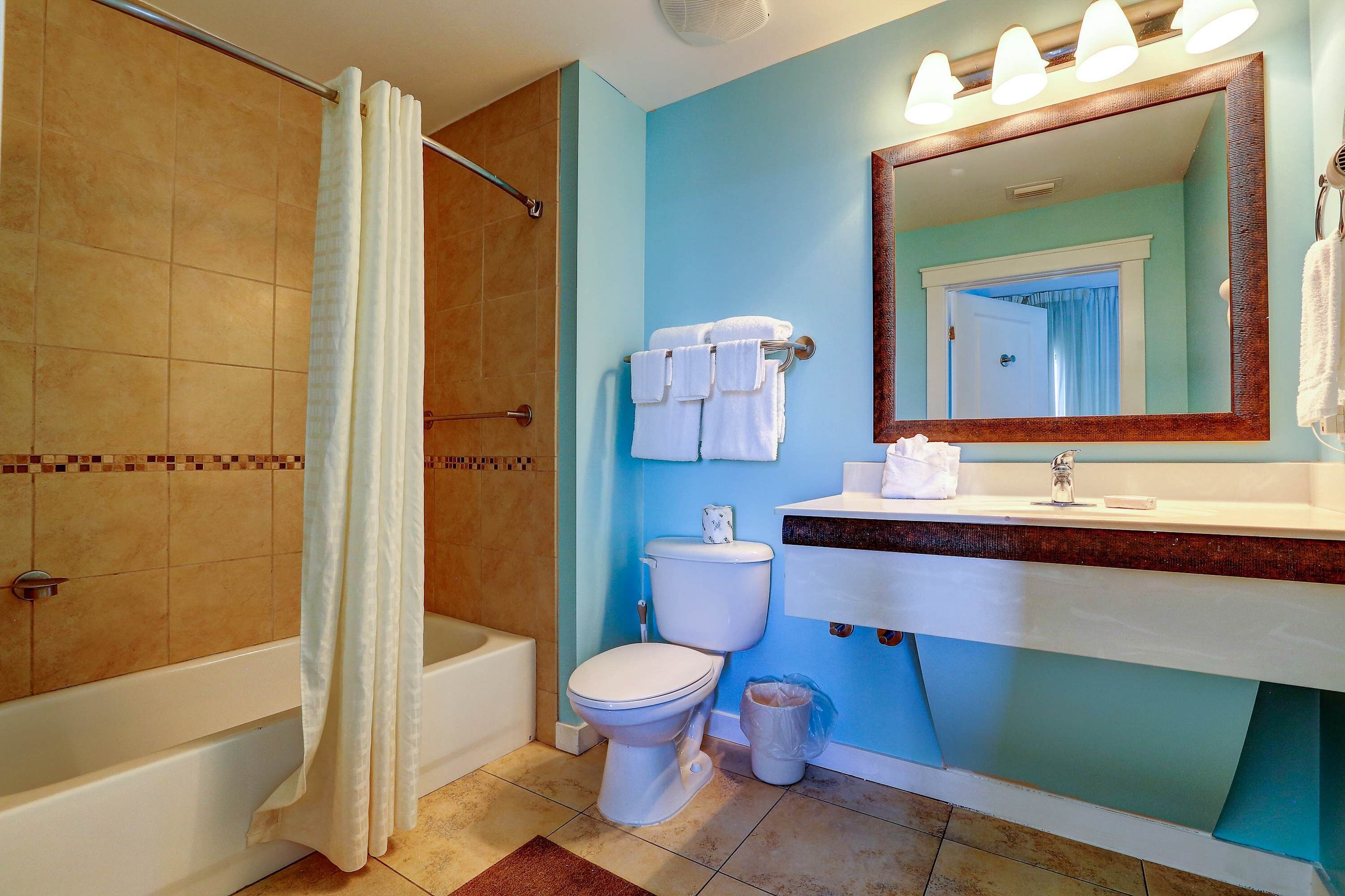 A bathroom with a bathtub, toilet, and sink.