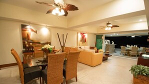 A spacious living area with a dining table, comfortable seating, and ceiling fans. - Bay View Grand Residencial 11th floor (Ixtapa Zihuatanejo)