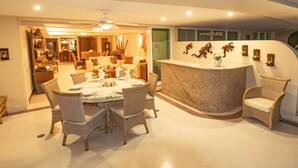 A spacious dining area with a marble counter and wicker chairs. - Bay View Grand Residencial 11th floor (Ixtapa Zihuatanejo)